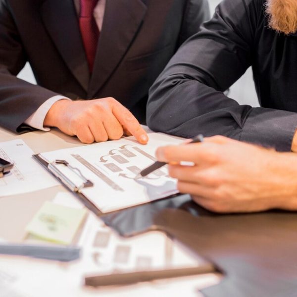 close-up-two-businessmen-pointing-business-chart-meeting_23-2147923347